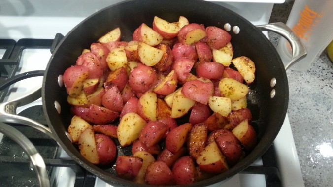 Red potatoes in the frying pan with seasonings